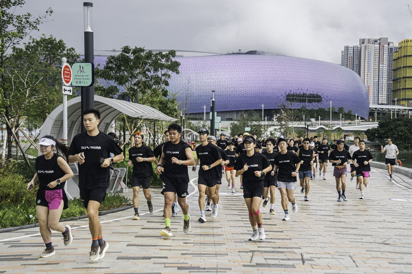 Mount to Coast community run in Hong Kong, runners in black MTC shirts along the Kai Tak waterfront